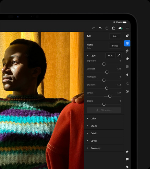 iPad Pro, front exterior, landscape orientation, space black colour, display showing a photograph being edited of a person in a colourful sweater, tools and effects menu open at right