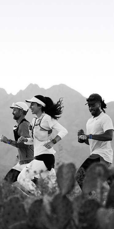 Three people running on a desert trail track their workouts on Apple Watch Ultra 3