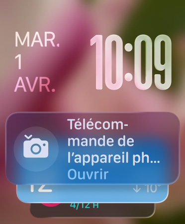 Le widget Télécommande de l’appareil photo apparaît en bas de l’écran, l’heure en chiffres translucides en haut à droite, la date en haut à gauche