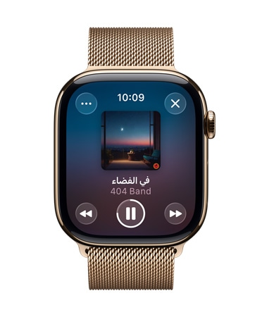 صورة لساعة Apple Watch من التيتانيوم بلون ذهبي مع حزام Loop ميلانيز، وتعرض واجهة الساعة موسيقى Apple Music وأدوات تحكم بتصميم Liquid Glass شبه شفاف‏