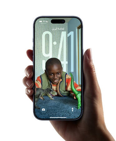 يد تحمل جهاز iPhone يعرض تصميم Liquid Glass الجديد الذي يتيح لأرقام الوقت التكيف بشكل ديناميكي مع الصورة على شاشة القفل