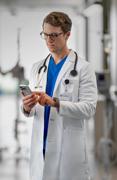 Om de pols van een zorgverlener zit een Apple Watch met een medicatiemelding uit de Epic-app.