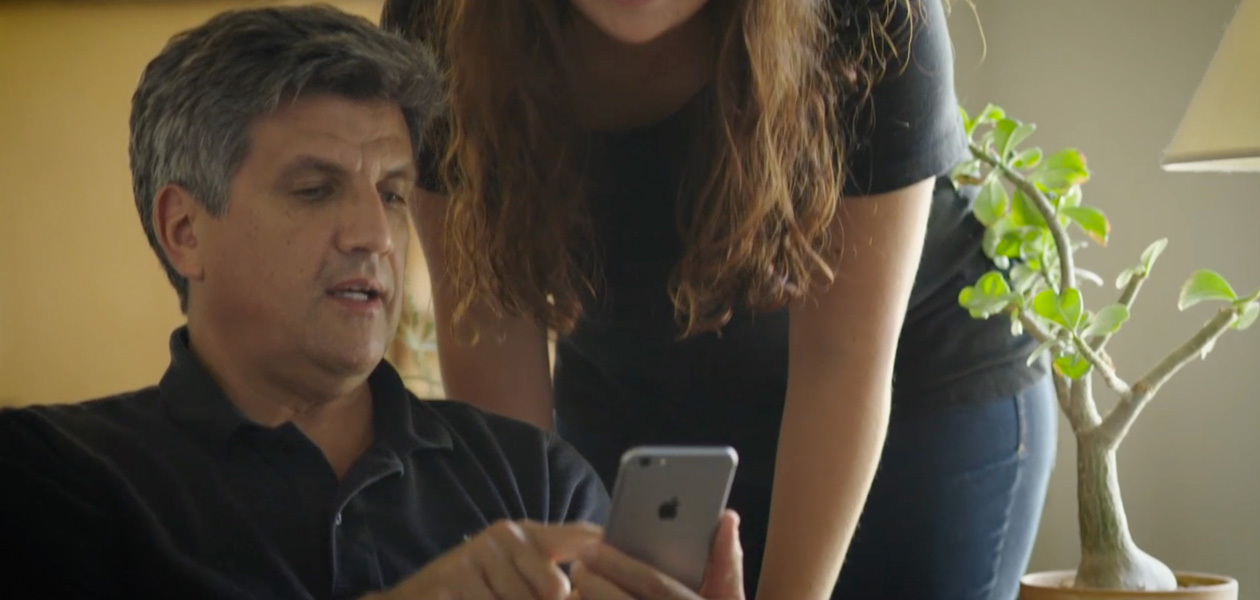 Một người đàn ông đang chia sẻ thông tin sức khỏe của mình trên iPhone với người phụ nữ ở bên cạnh.