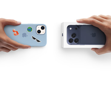 Händer som byter in en begagnad enhet. En iPhone 13 i silikonskal med klistermärken på baksidan byts mot en ny iPhone 17 som ligger i sin förpackning.